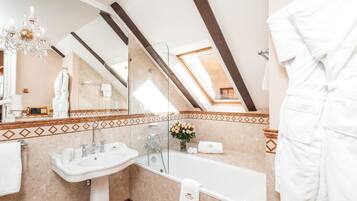 Une salle de bain moderne avec un puits de lumière, une baignoire, un lavabo et un miroir.
