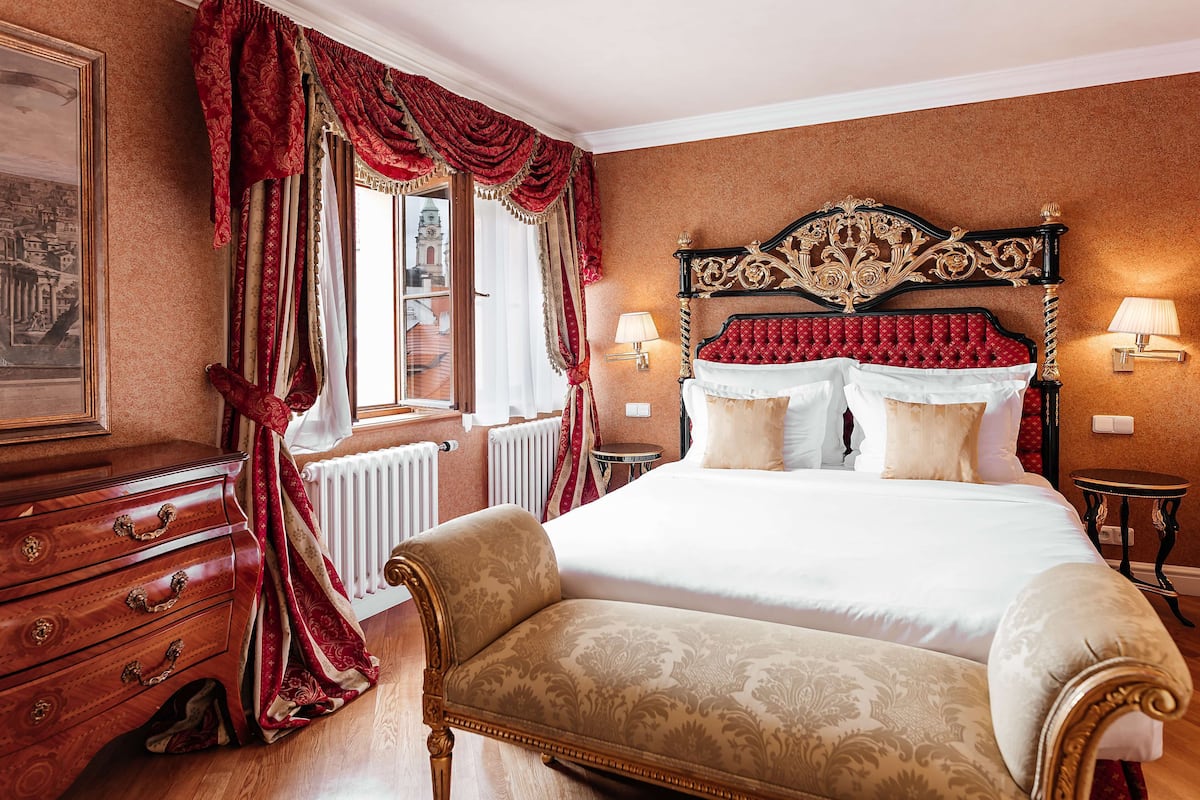 Ein Hotelzimmer mit einem großen Bett, einem Holzschrank und einem Stuhl.