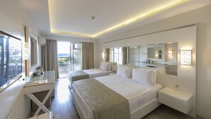 A modern hotel room with two beds, a desk, and a balcony with a view. - Mavi Deniz Otel - All Inclusive (Marmaris)