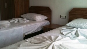 A hotel room with two beds, wooden headboards, and a wardrobe. - Gaye Apart (Ula)