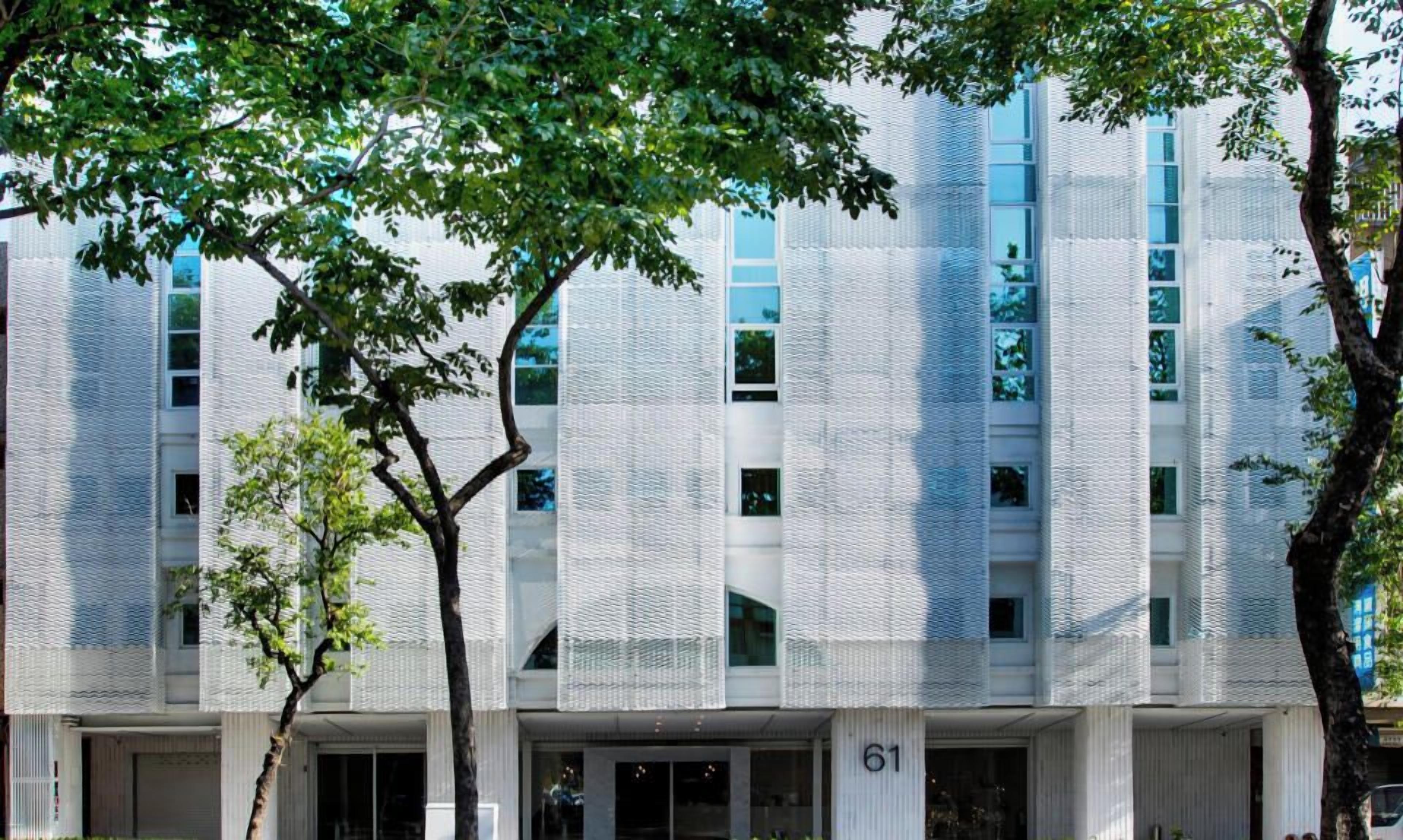 A modern building with a textured facade and multiple windows.