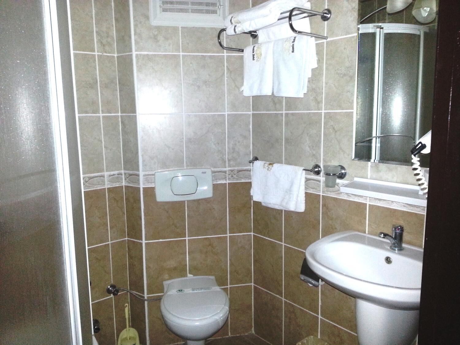 Ein Badezimmer mit Toilette, Waschbecken und Handtuchhalter.