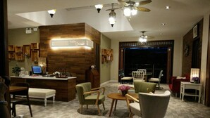 A modern hotel lobby with a reception desk, seating area, and a large window. - Bann Vimansamutr (Cha-am)