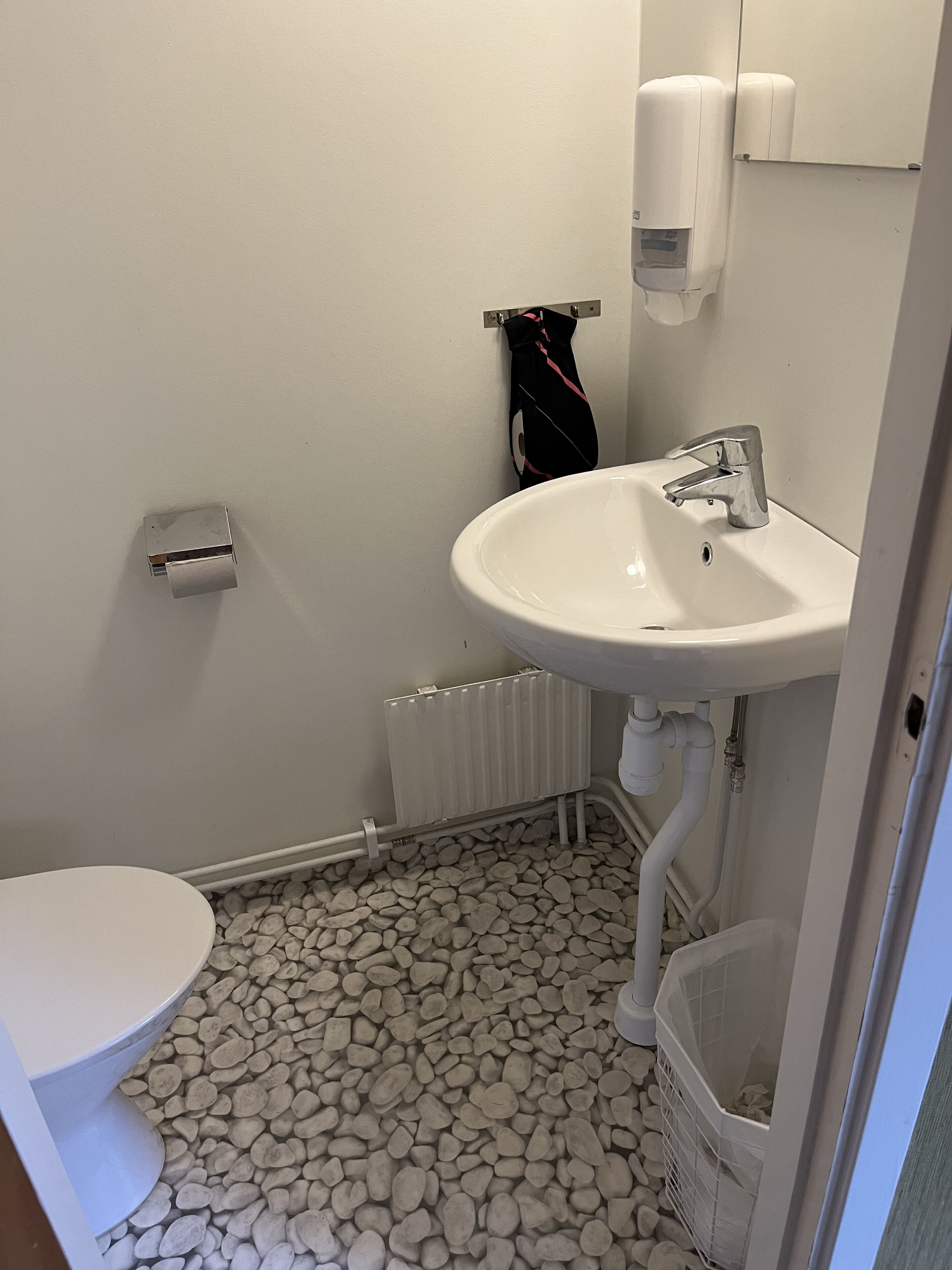A bathroom with a white sink, toilet, and radiator.