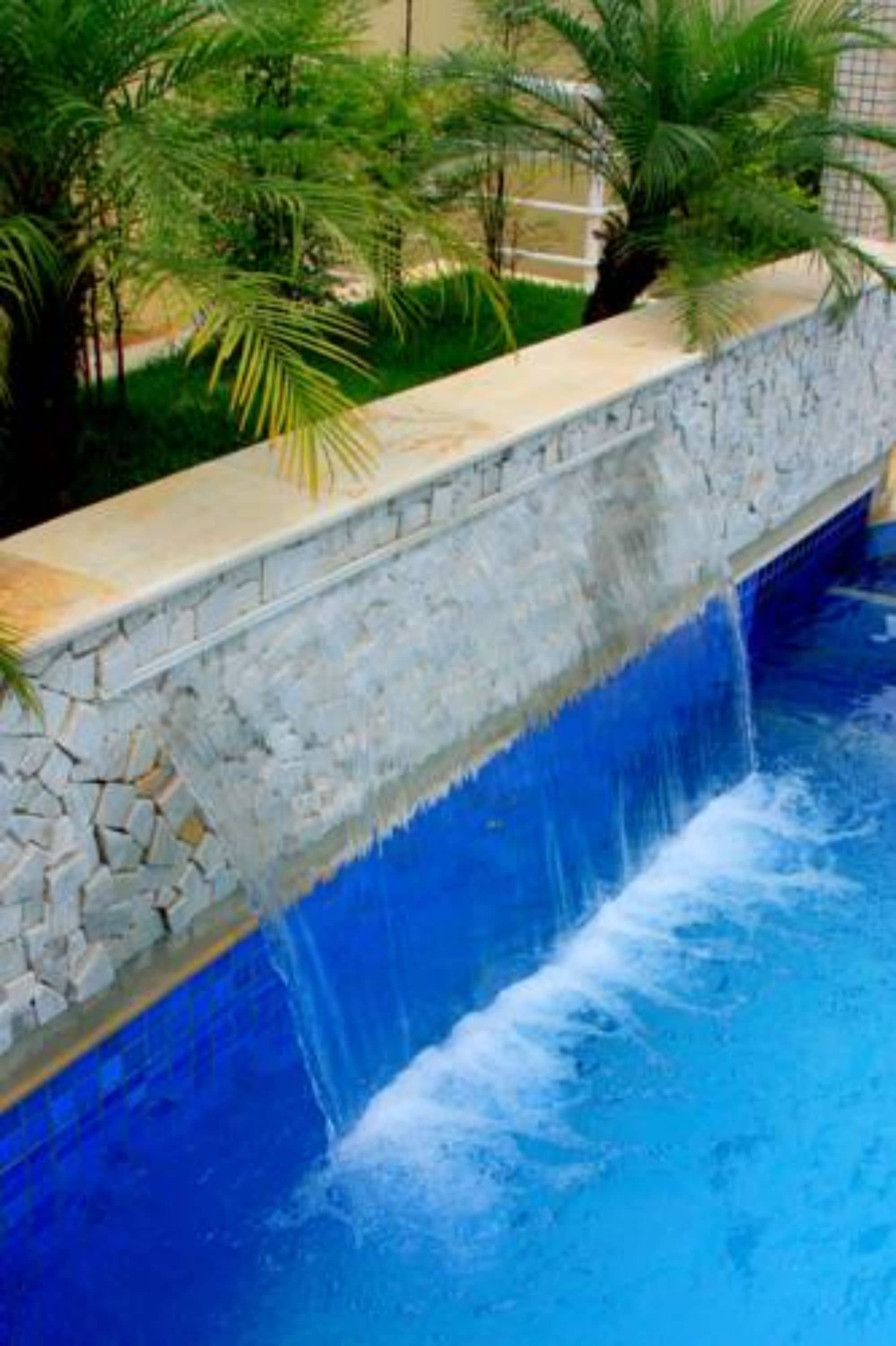 Una piscina al aire libre, sillones reclinables de piscina