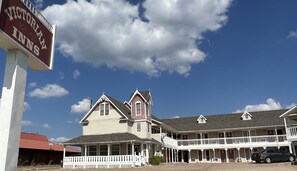 Victorian Inns with a two-story building, a balcony, and a signboard.