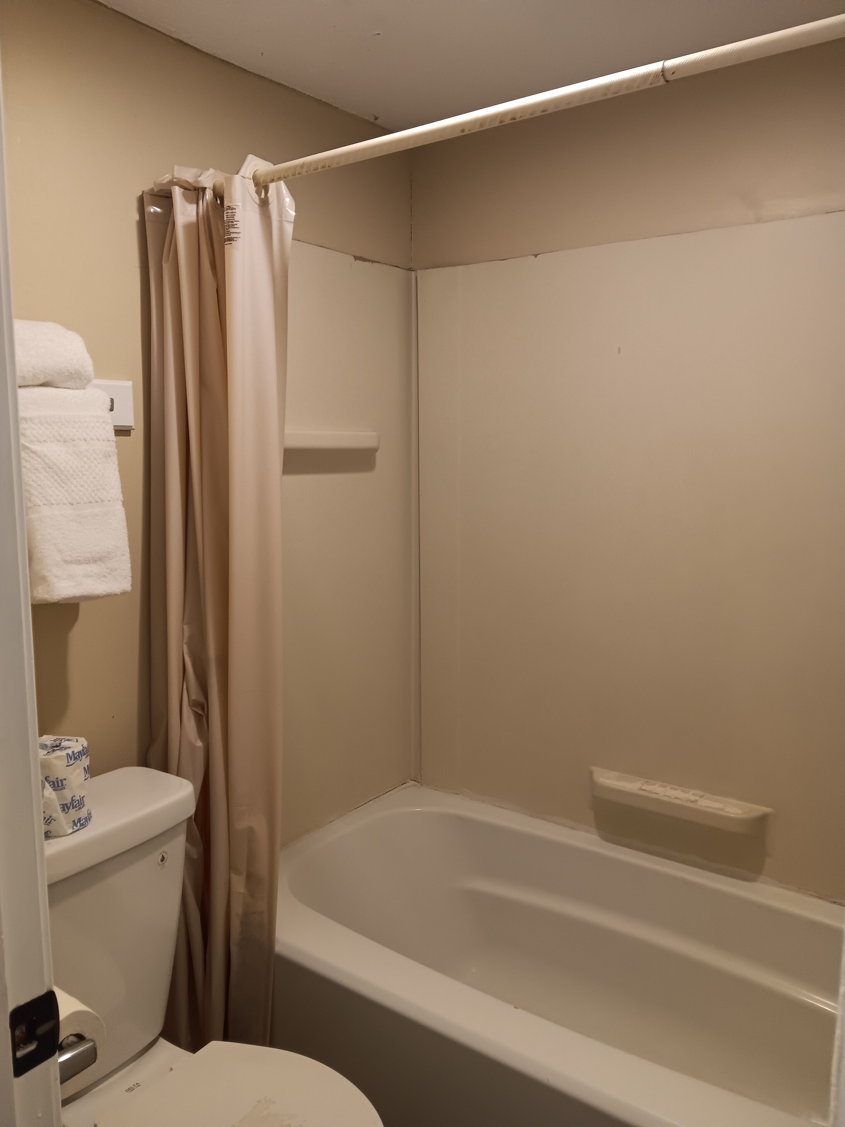 Un baño con bañera, inodoro y cortina de ducha.