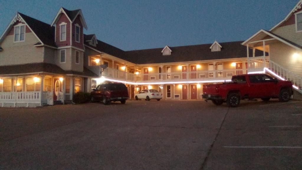 A motel with a central building and a covered parking area.