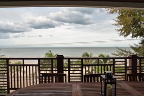 A wooden deck with a view of the beach and ocean. - The Beach Palace 2BR Luxury Beachfront (Cha-am)