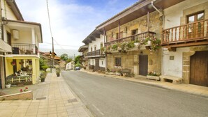 A street with buildings, some with balconies and flower boxes. - Posada de Villacarriedo (Villacarriedo)