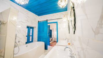 Une salle de bain moderne avec une grande baignoire, un lavabo et une douche.
