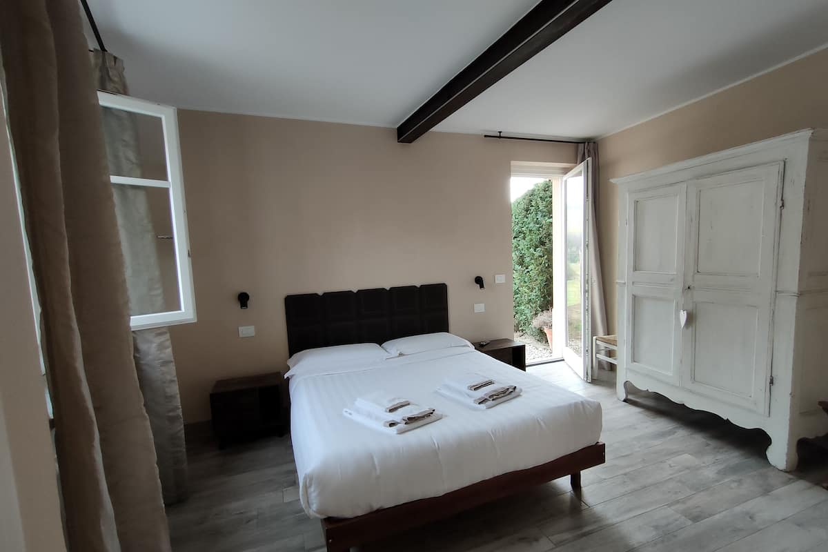 Een slaapkamer met een bed, nachtkastjes, een kledingkast en een raam.