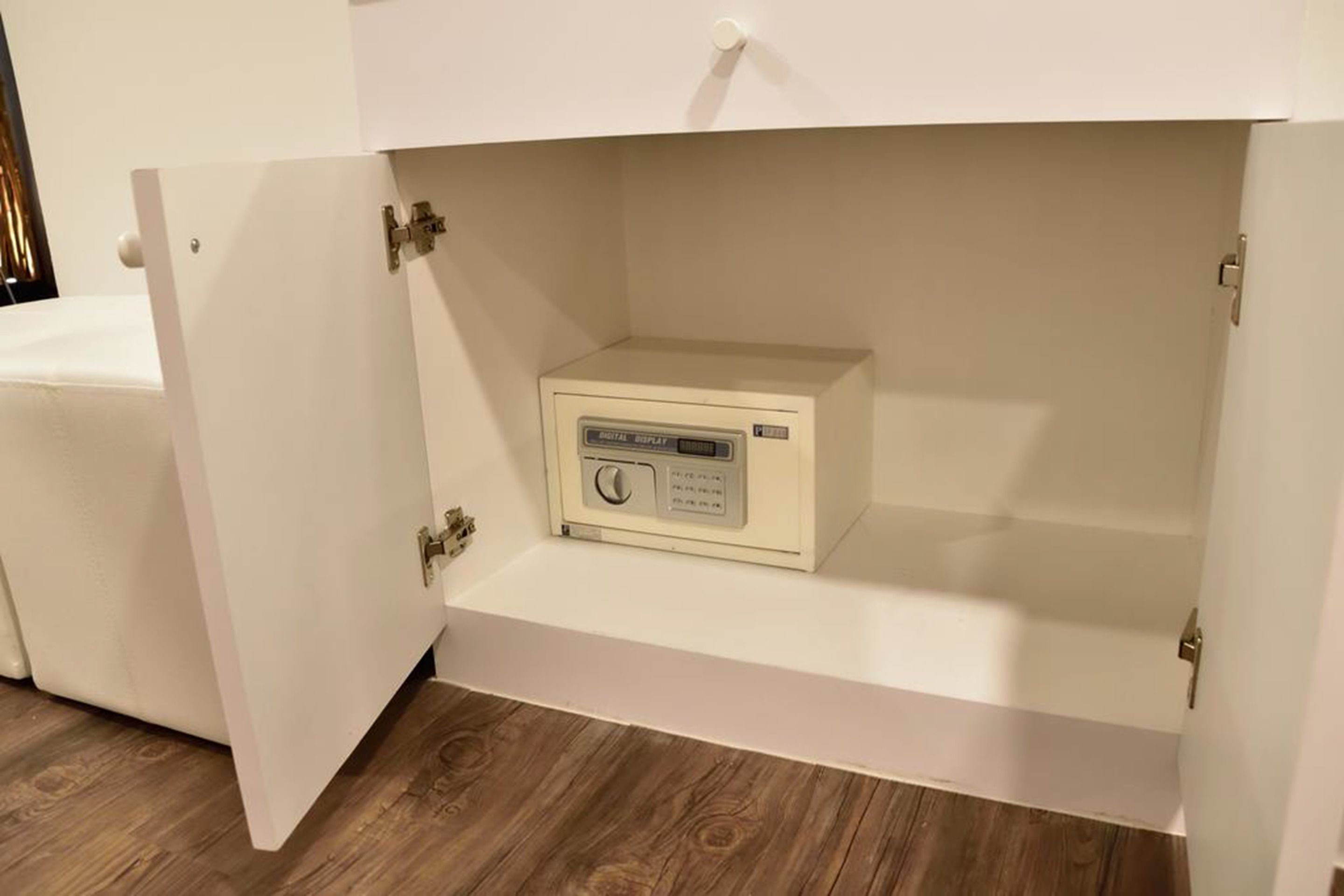 A white cabinet with a digital display device inside.