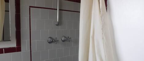 A bathroom with a shower, a sink, and a mirror.