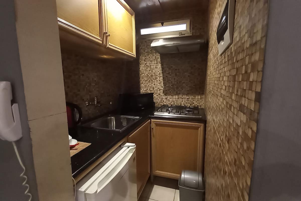 A compact kitchen with a stove, sink, and cabinets.