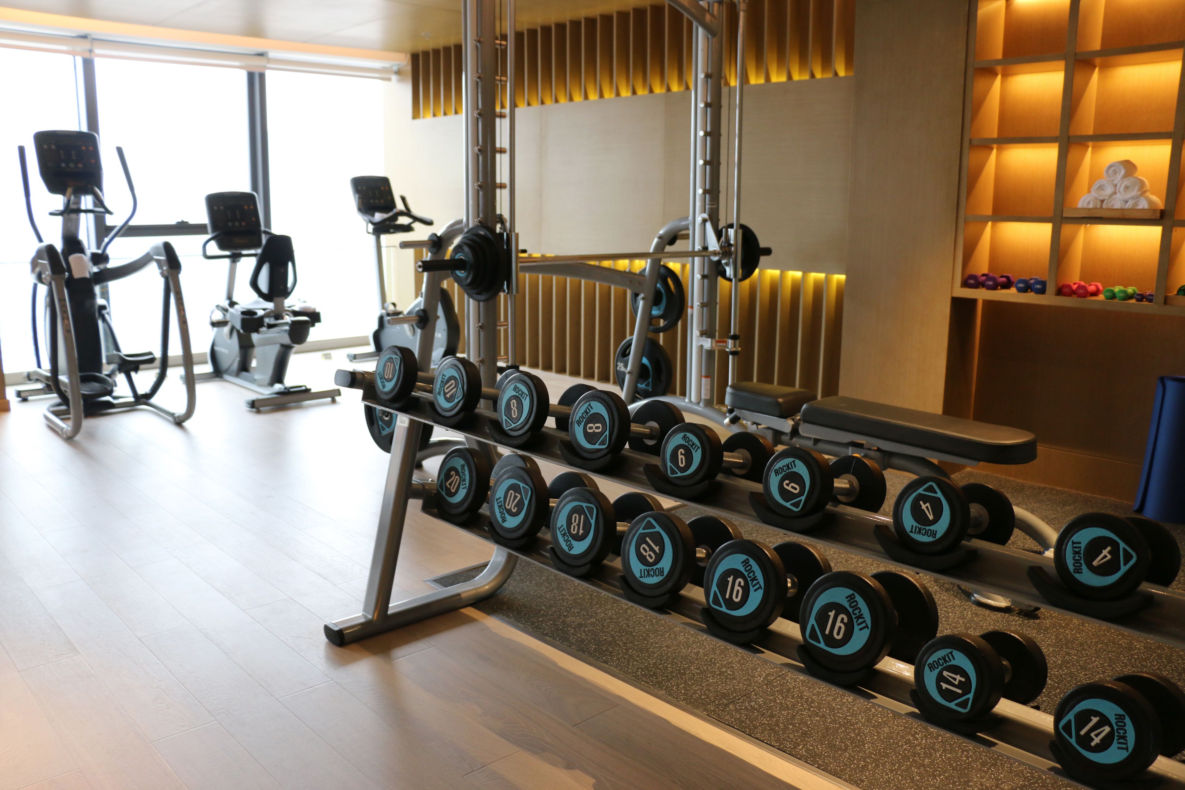 Ein Fitnessraum mit Trainingsgeräten und Kurzhanteln.