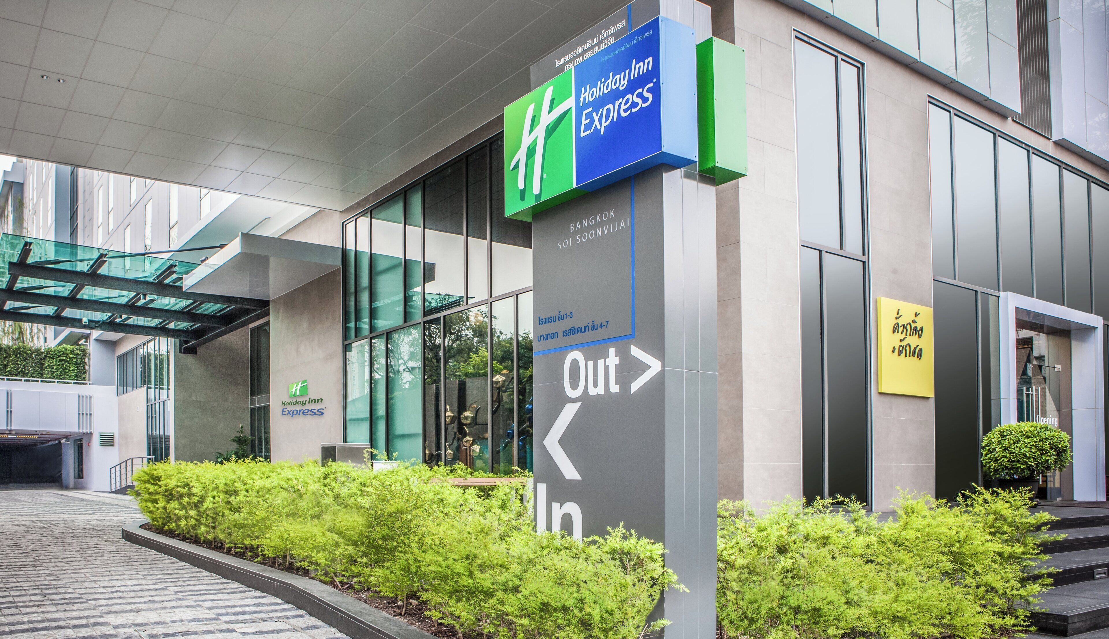 Señal de Holiday Inn Express con flechas direccionales que indican la salida y la entrada.