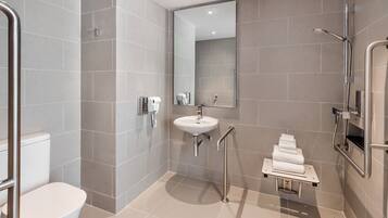 A modern bathroom with a toilet, sink, and shower.