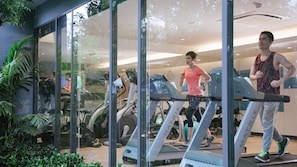 Un gimnasio con cintas de correr, bicicletas estáticas y pelotas de ejercicio.