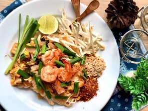 A plate of Pad Thai with shrimp, bean sprouts, lime, and green onions. - Holiday Inn Express Bangkok Soi Soonvijai by IHG (Bangkok)