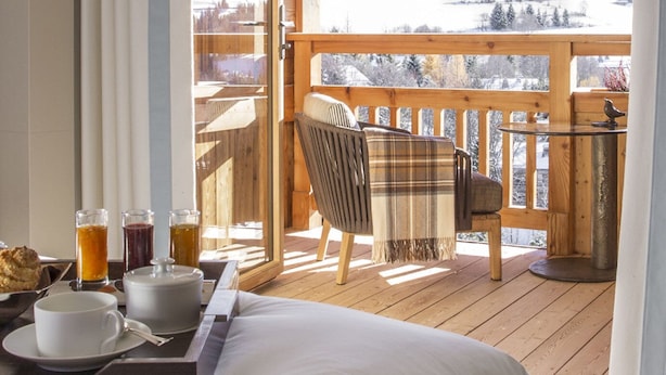 A wooden balcony with a view of a snowy mountain landscape.