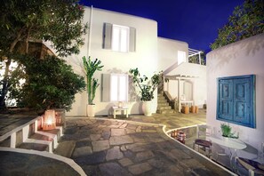 A modern building with a stone courtyard, a staircase, and a blue door. - Mykonos Town Suites (Mykonos)