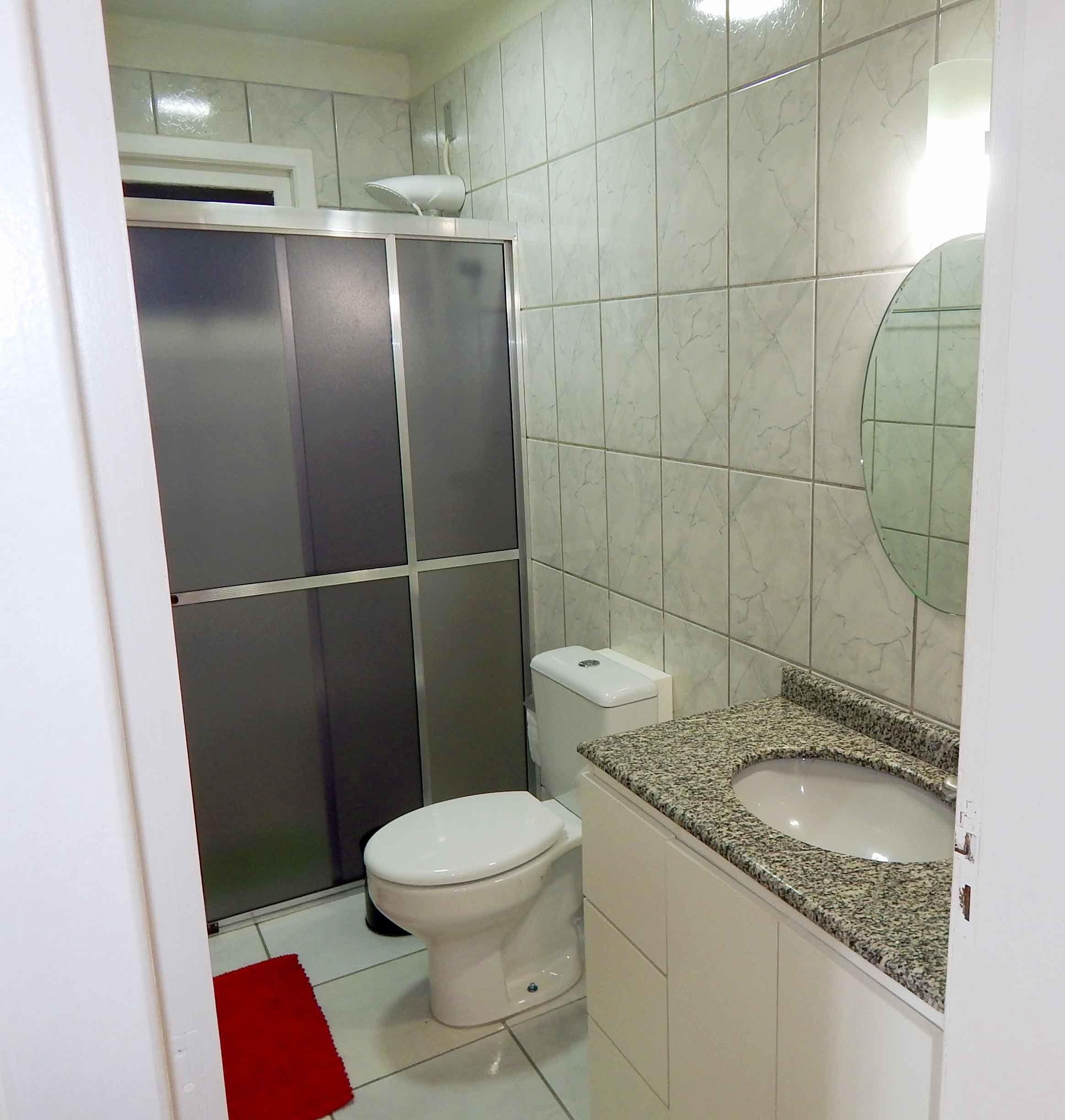 Une salle de bain comprenant des toilettes, un lavabo et un espace douche.