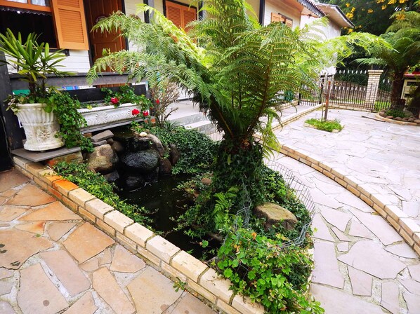 Stroll through the serene garden, surrounded by lush greenery and a tranquil pond.