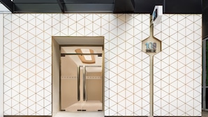 A hotel entrance with a geometric patterned facade, a prominent number sign, and a modern design. - Hotel 108 (Kowloon)