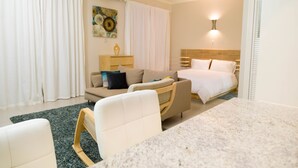 Ein Hotelzimmer mit Bett, Sofa, Schreibtisch und Stuhl.