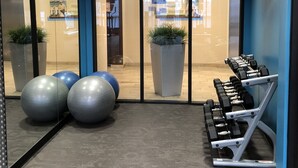 Une salle de sport équipée de matériel d’exercice, de grands ballons de gymnastique et d’un mur recouvert de miroirs.