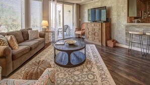 A living room with a sofa, coffee table, and a television. - 2201 SeaCrest. Renovated 1BR + Bunk Alcove — 2 Full Baths, Sleeps 6 (Hilton Head Island)