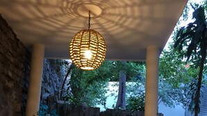 A ceiling with a woven light fixture, stone walls, and a view of trees and a building. - 2BED/2BA, Pool, Lush Gardens, Private Rooftop, Walk to Beach & Downtown (Bucerías)