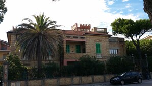 A two-story building with a brick facade, green shutters, and a balcony. - Air conditioned, brand new mini loft apartment first row sea (Tortoreto Lido)
