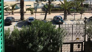 A coastal street with parked cars, palm trees, and a view of the beach. - Air conditioned, brand new mini loft apartment first row sea (Tortoreto Lido)