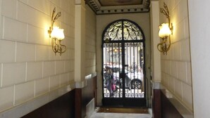 A corridor with white tiled walls, a decorative ceiling, and a black gate at the end. - New apartment, 6 pers, free WiFi, Sagrada Familia (Barcelona)