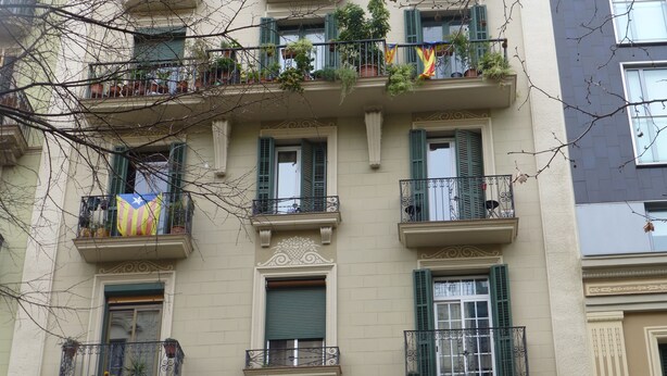 A multi-story building with balconies, some with plants and flags. - New apartment, 6 pers, free WiFi, Sagrada Familia (Barcelona)
