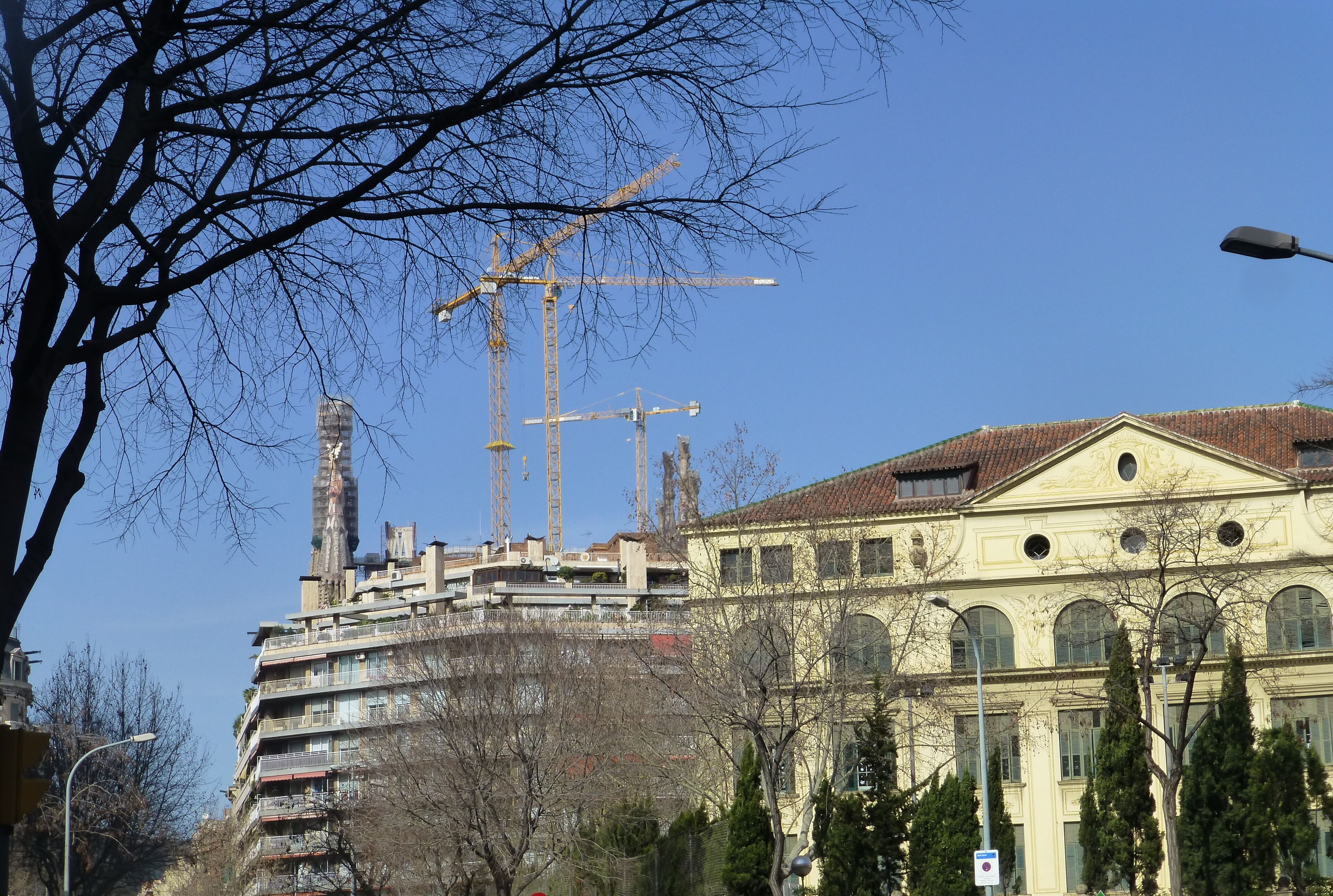Un edificio de varios pisos con una grúa de construcción al fondo.