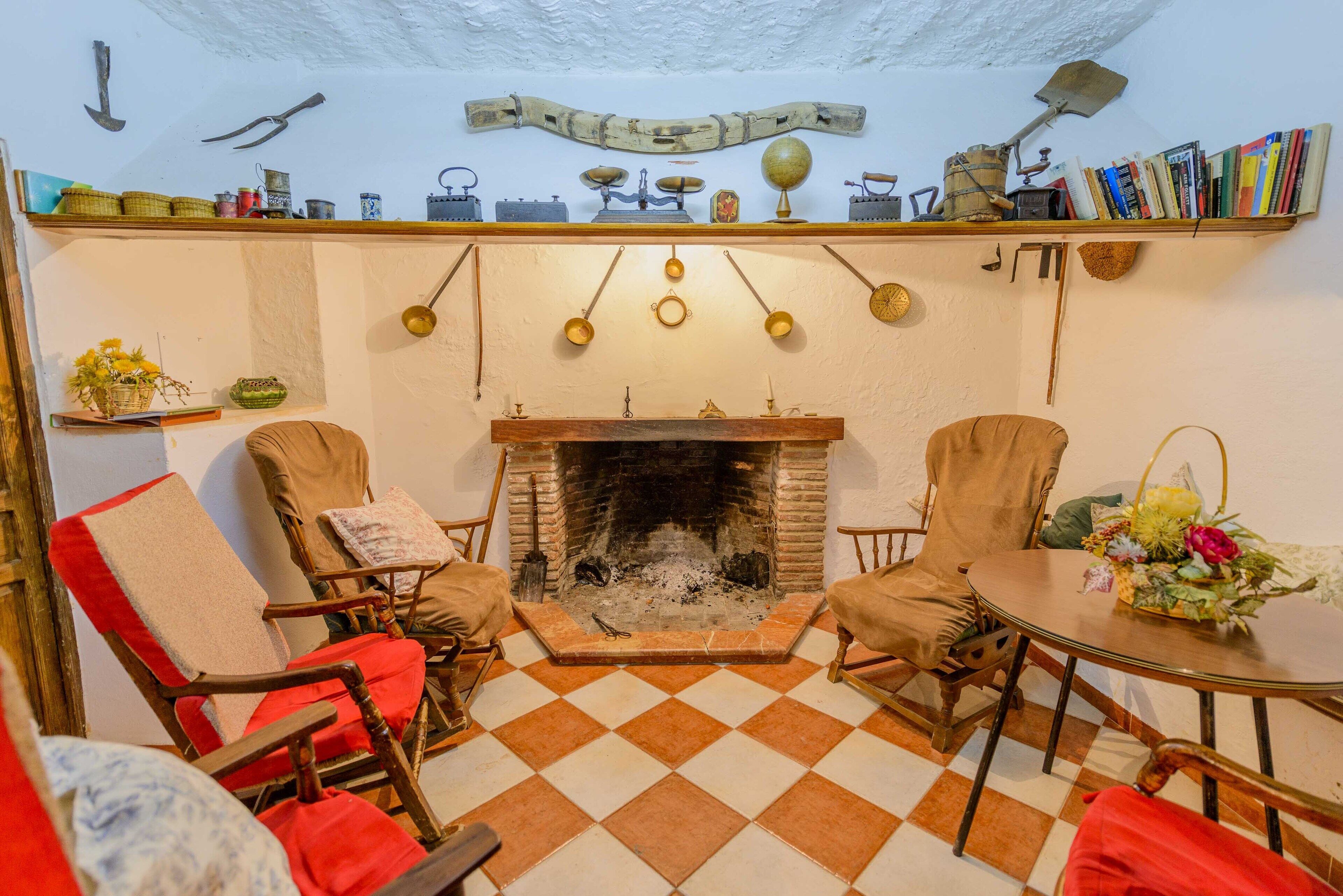 A cozy room with a fireplace, checkered floor, and wooden furniture.