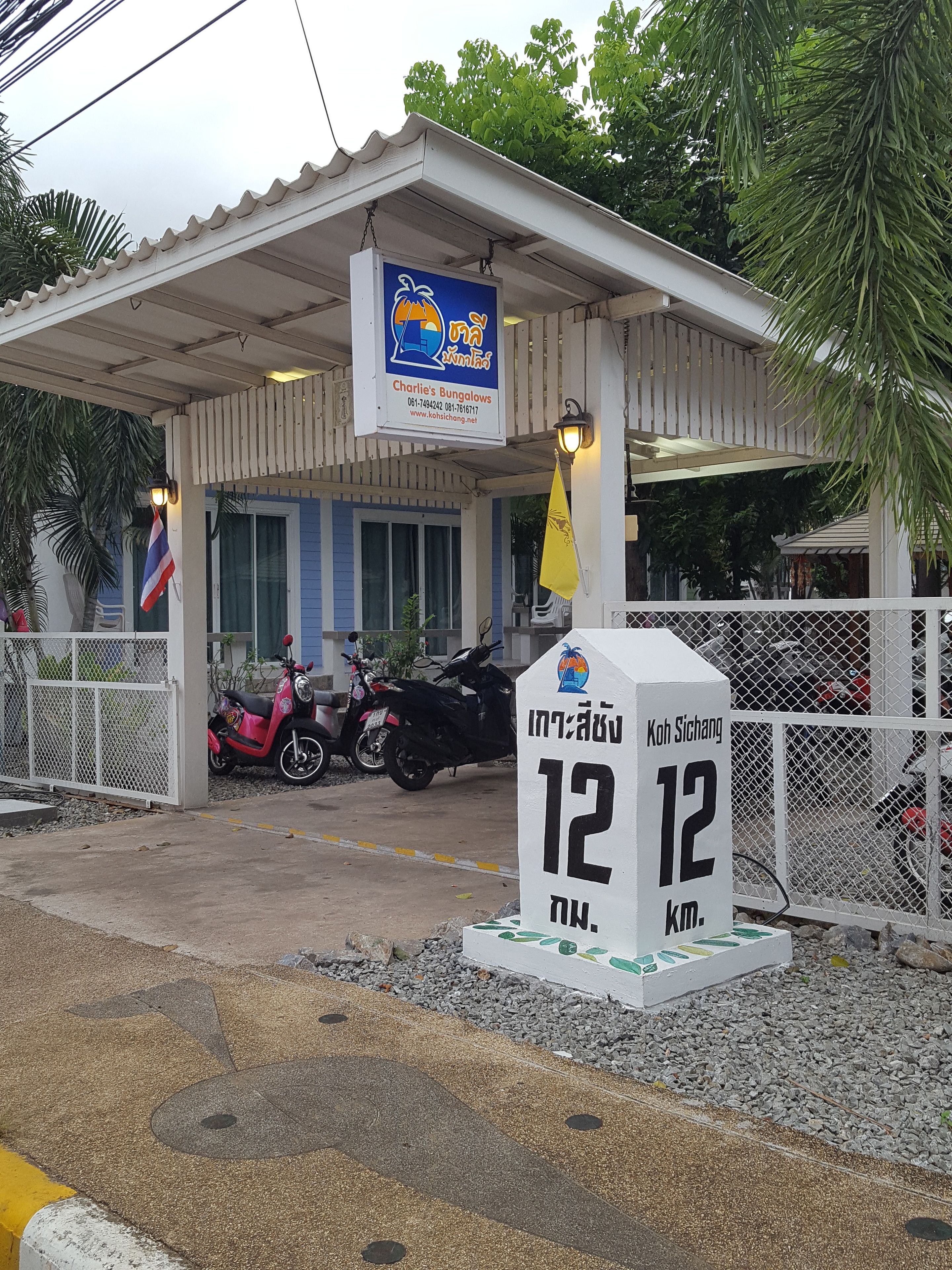A bungalows building with a signboard and a distance marker.