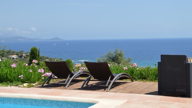 A poolside area with two lounge chairs facing the sea, a clear view of the ocean, and a distant coastline. - Luxury villa, heated pool, panoramic sea view, air conditionin (Roquebrune-Sur-Argens)