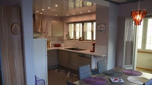A modern kitchen with a built-in dishwasher, a sink, and a window with lace curtains. - Center Alsace, house 2 to 5 pers. Between Colmar and Strasbourg. Exceptional view (Neubois)
