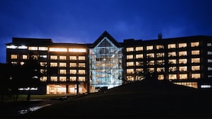 A modern building with multiple floors, large windows, and a central glass facade. - Yakushima Iwasaki Hotel (Yakushima)