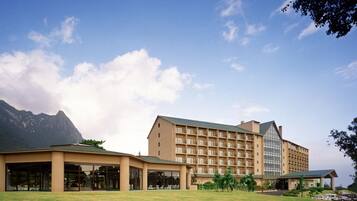 A hotel with a large building, multiple balconies, and a covered outdoor area.