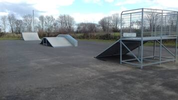 En parkeringsplats med en ramp som leder till en grindad entré.
