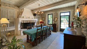 A rustic dining area with a stone fireplace, wooden ceiling beams, and a table set for four. - Luxury Mas 5★ in St-Rémy - Heated pool, Spa, Poolhouse - MAS CHANTE-MERLE (Saint-Rémy-De-Provence)