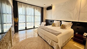A modern bedroom with a large bed, a bedside table, a TV, and a wall-mounted artwork. - Luxury Mas 5★ in St-Rémy - Heated pool, Spa, Poolhouse - MAS CHANTE-MERLE (Saint-Rémy-De-Provence)