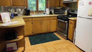 A kitchen with wooden cabinets, a stove, a microwave, and a refrigerator. - Minutes from Everything- Lambeau Field,  Door County and more !, (Hobart)