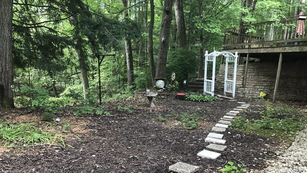 A forested area with a stone pathway leading to a wooden structure. - Minutes from Everything- Lambeau Field,  Door County and more !, (Hobart)
