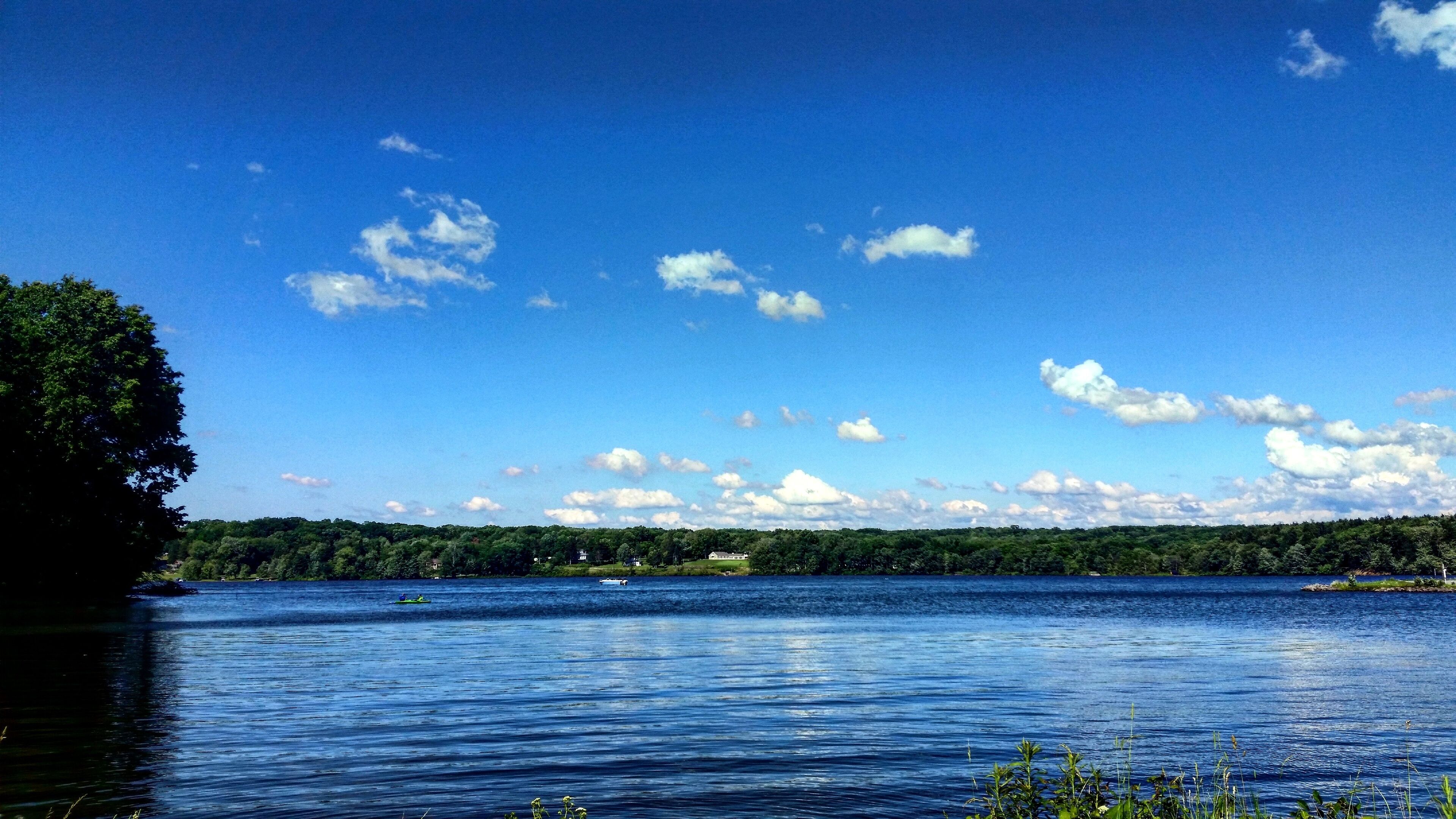 A lake with a clear sky and scattered clouds.